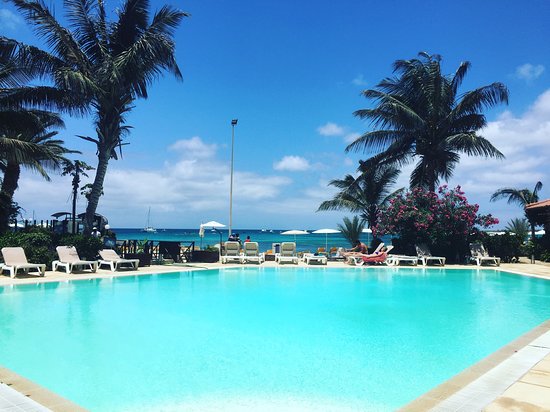 Beachfront pool with palm trees at Porto Antigo II, Santa Maria, Cape Verde